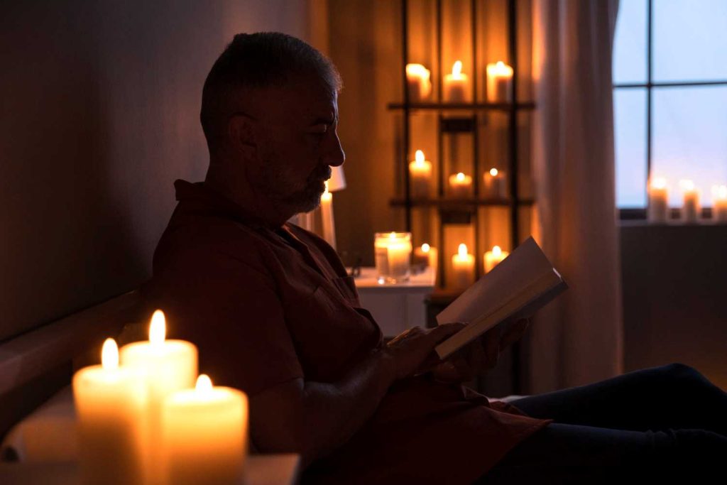 man reading candlelight